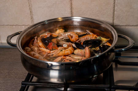 fish soup in the pan with wood mixture during cookingの写真素材