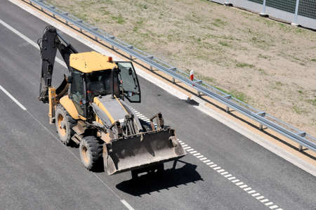 Construction car - digger on recently finished highway