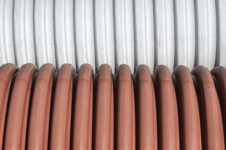 Drainage pipes on building site  White and red plastic tubes or building materials in pvcの写真素材