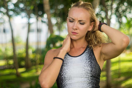 Blond girl, wears sportswear and does exercise in the garden. Natural and with tennis racket. He enjoys making gestures and curious and very original expressions. Young, beautiful and sexy.の写真素材
