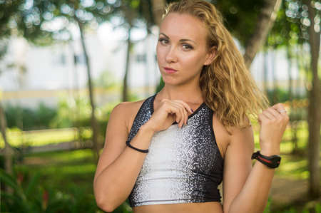 Blond girl, wears sportswear and does exercise in the garden. Natural and with tennis racket. He enjoys making gestures and curious and very original expressions. Young, beautiful and sexy.の写真素材