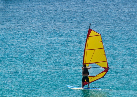 Giovane uomo fa windsurf nel mare di Siciliaのeditorial素材
