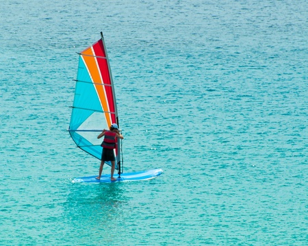 Giovane uomo impara il windsurf nel mare di siciliaのeditorial素材