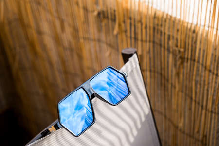 Aviator Sunglasses model for men with big blue lens reflecting the sun. Selective focusの写真素材
