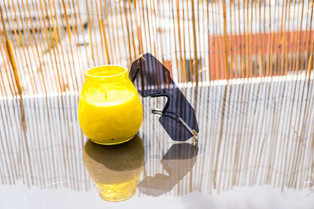 Futuristic sunglasses rimless stay on table outside with bamboo fence background. Selective Focusの写真素材