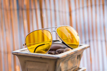 Retro aviator sunglasses model with big yellow lenses recommended for driving in a summer day...