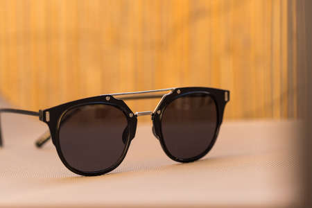 Black sunglasses classic design in a sunny day of summer closeup. Selective Focus