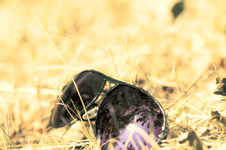 Retro aviator sunglasses model with blue lenses reflecting the sun in a summer day closeup . Selective focusの写真素材