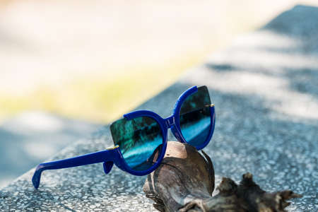 Cat eye sunglasses model for ladies with blue lenses in a summer day closeup. Selective focusの写真素材