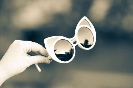 Cat eye sunglasses hold by hand shoot outside closeup. Selective focusの写真素材