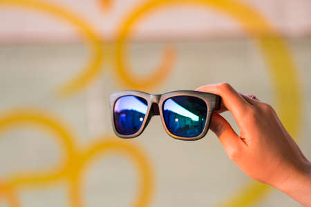 Classic sunglasses model hold by hand in a summer day closeup. Selective focusの写真素材