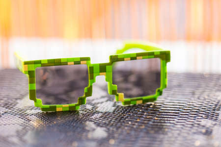 Green pixel sunglasses with black lenses closeup in a sunny day. Selective focusの写真素材