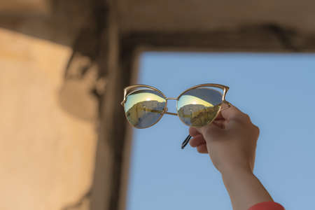 Fashion cat eye sunglasses model for women hold by hand shoot outside in a summer day closeup....