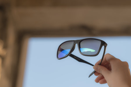 Retro Sunglasses model shoot in a urban location in a sunny day hold by handの写真素材