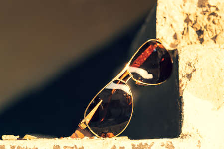 Aviator Sunglasses model with big black lenses for men shoot in a urban place in a summer day closeup . Selective focusの写真素材