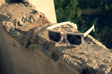 White pixel sunglasses with black lenses closeup in a sunny day. Selective focusの写真素材