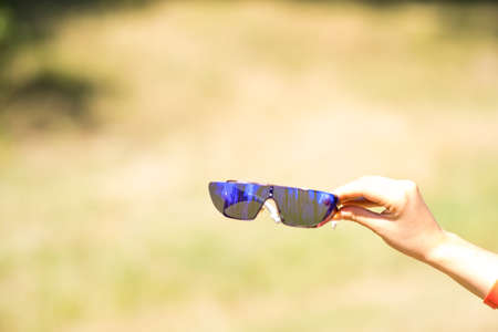 Futurisic Sunglasses hold In hand in a sunny day Closeup. Selective Focusの写真素材