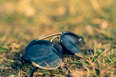 Sunglasses with round lens shoot outdoors in a sunny day closeup. Selective Focusの写真素材