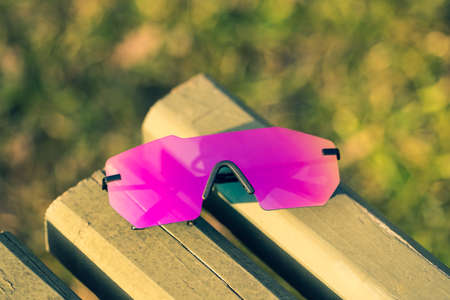 Futuristic sunglasses model rimless with big pink lens reflecting the sun in a summer day closeup. Selective focusの写真素材