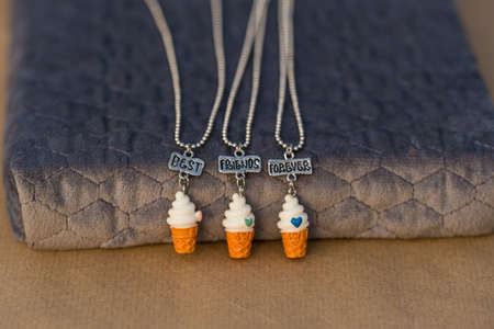 Best friends forever necklace pendant shoot outside in a summer day closeup. Selective Focus