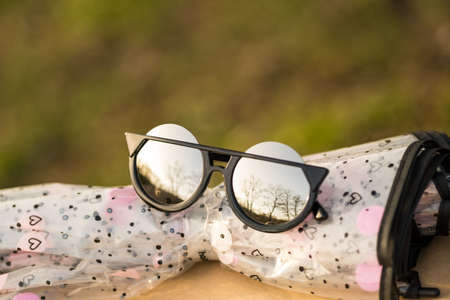 Sunglasses special model with big silver lenses for ladies with special design shoot outdoors in a sunny day closeup. Selective focusの写真素材