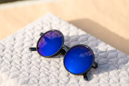 Sunglasses with big blue round lenses shoot outside in a sunny day closeup. Selective Focusの写真素材