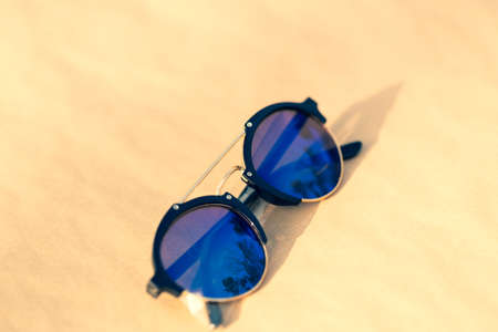 Retro sunglasses model with blue round lenses shoot outside in a summer day closeup . Selective focusの写真素材