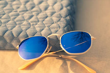 Classic sunglasses model with blue lenses shoot outside in a sunny day closeup . Selective focusの写真素材