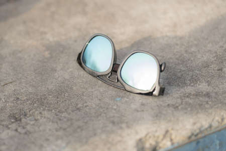 Sunglasses model with blue green lenses shoot outside in a summer day closeup . Selective focusの写真素材