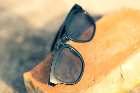 Sunglasses with black lenses and black frame shoot outside in a sunny day closeup . Selective focusの写真素材