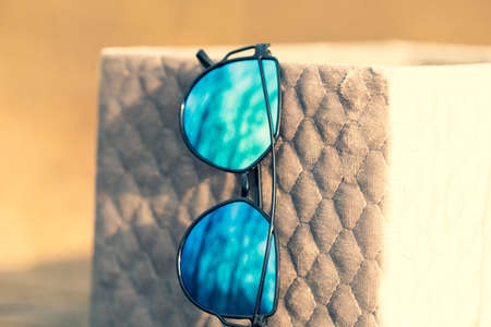 Cat eye sunglasses special model with blue lenses and black frame for ladies shoot in a summer day. Selective focusの写真素材