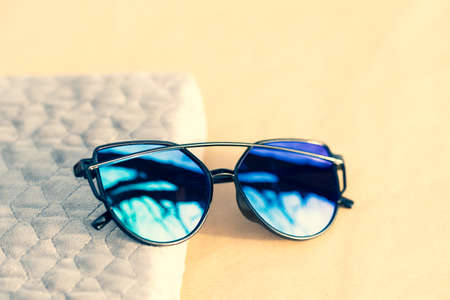 Sunglasses special model with blue lenses and black frame for ladies shoot in a summer day. Selective focusの写真素材