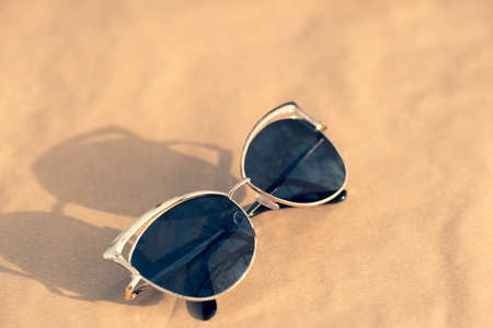 Fashion cat eye sunglasses model for ladies with black lenses and golden frame shoot outside in a sunny day closeup. Selective focusの写真素材