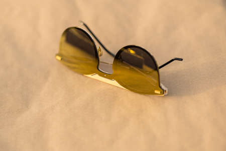 Special design Sunglasses with golden round lenses shoot outside in a sunny day closeup. Selective Focusの写真素材