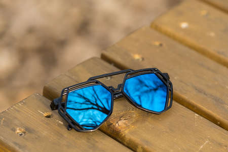 Futuristic aviator sunglasses model with big blue lenses closeup shoot outside in a summer day . Selective focusの写真素材