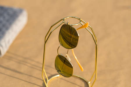 Classic sunglasses model with golden lenses shoot outside in a sunny day closeup . Selective focusの写真素材