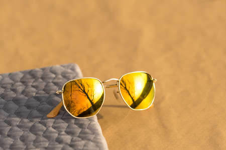 Classic sunglasses model with golden lenses shoot outside in a sunny day closeup . Selective focusの写真素材