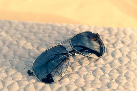 Classic aviator sunglasses model with big black lenses shoot outside in a summer day closeup . Selective focusの写真素材