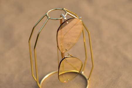 Aviator Sunglasses model with big pink lenses reflecting the sun in a summer day closeup . Selective focusの写真素材