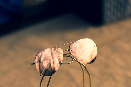 Aviator Sunglasses model with big pink lenses reflecting the sun in a summer day closeup . Selective focusの写真素材