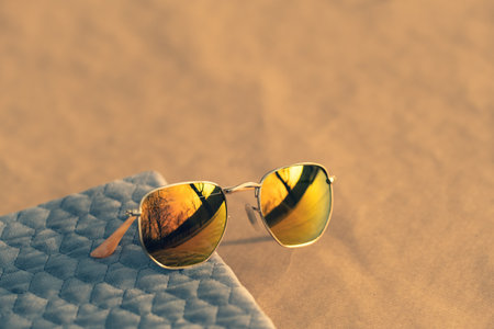 Classic sunglasses model with round golden lenses shoot outside in a summer day closeup . Selective focusの写真素材