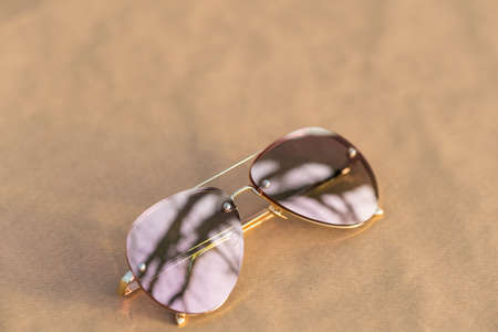 Aviator Sunglasses model with big pink lenses reflecting the sun shoot outside in a summer day closeup . Selective focusの写真素材