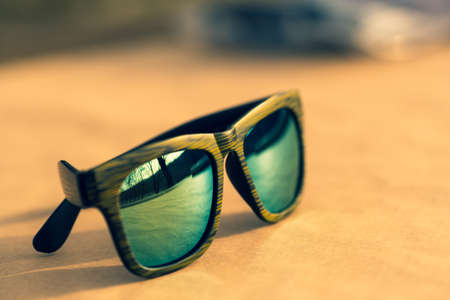 Classic sunglasses model with reflecting lenses and green frame in a sunny day closeup . Selective focusの写真素材