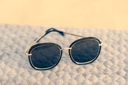 Sunglasses with big black round lenses shoot outdoors in a summer day closeup. Selective Focus