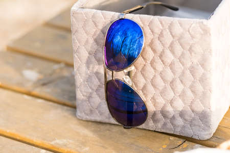 Classic aviator sunglasses model with big blue lenses shoot outside in a sunny day closeup . Selective focusの写真素材