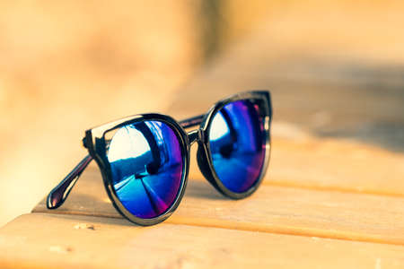 Fashion cat eye sunglasses model for ladies with big blue lenses and black frame shoot outside in a...
