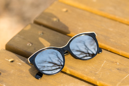 Fashion cat eye sunglasses model for ladies with big round silver lenses and black frame shoot outside in a sunny day closeup. Selective focusの写真素材