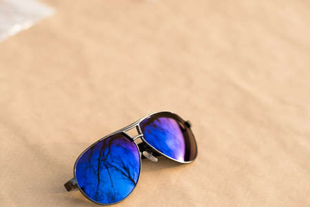 Classic aviator sunglasses model with big blue lenses shoot outside in a sunny day closeup . Selective focusの写真素材