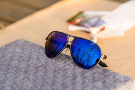 Classic aviator sunglasses model with big blue lenses shoot outside in a sunny day closeup . Selective focusの写真素材