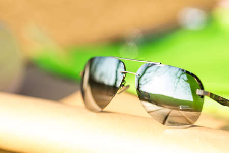 Aviator sunglasses model with big silver lenses shoot outside in a sunny day closeup . Selective focusの写真素材